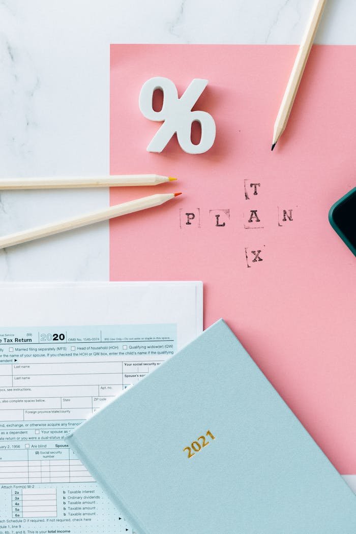 Flat lay of tax forms, calendar, and pencils illustrating tax planning.